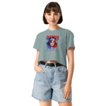 Woman wearing a light blue crop t-shirt with a graphic design and denim shorts on a white background