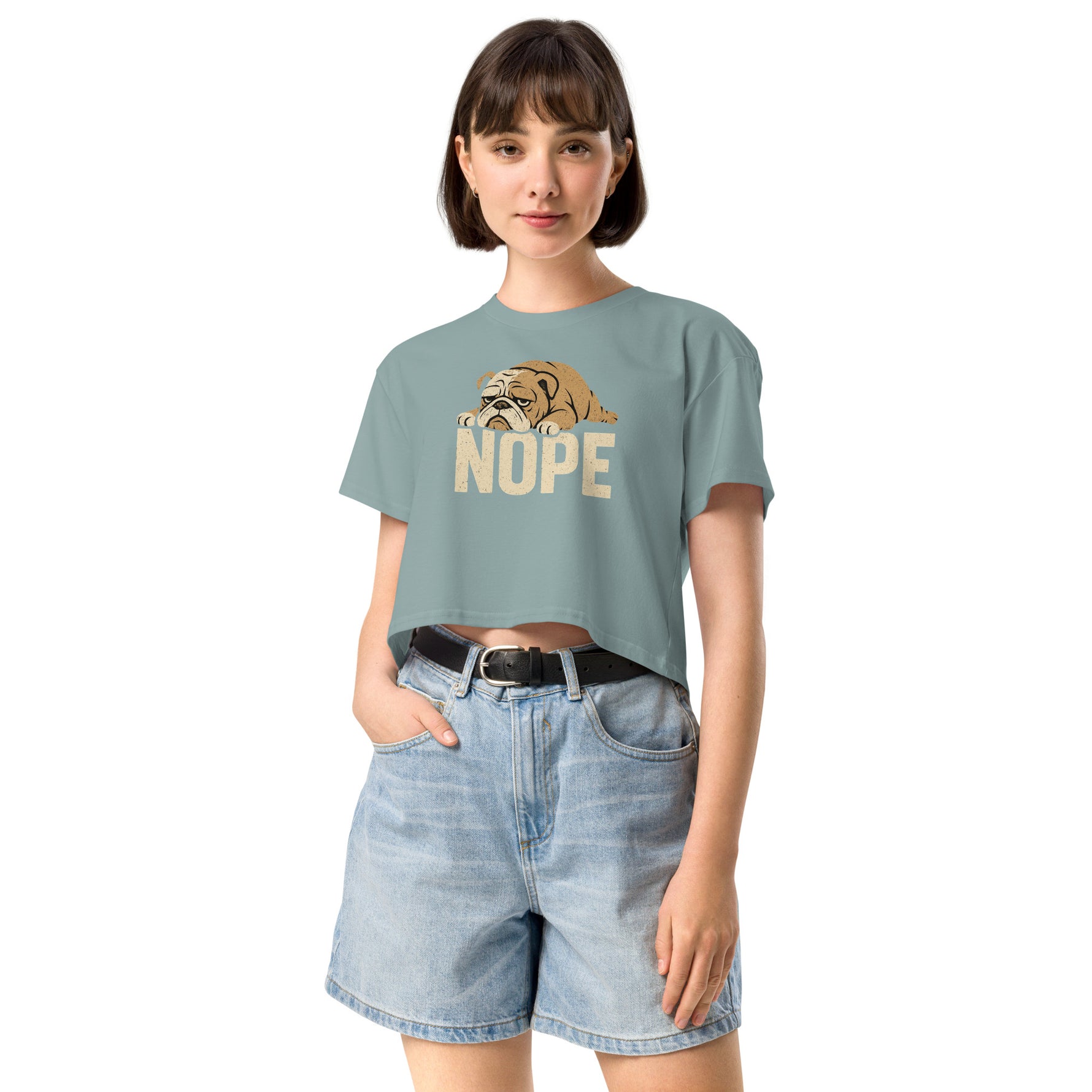 Woman wearing a light blue t-shirt with a dog graphic and 'NOPE' text, paired with denim shorts on a white background.