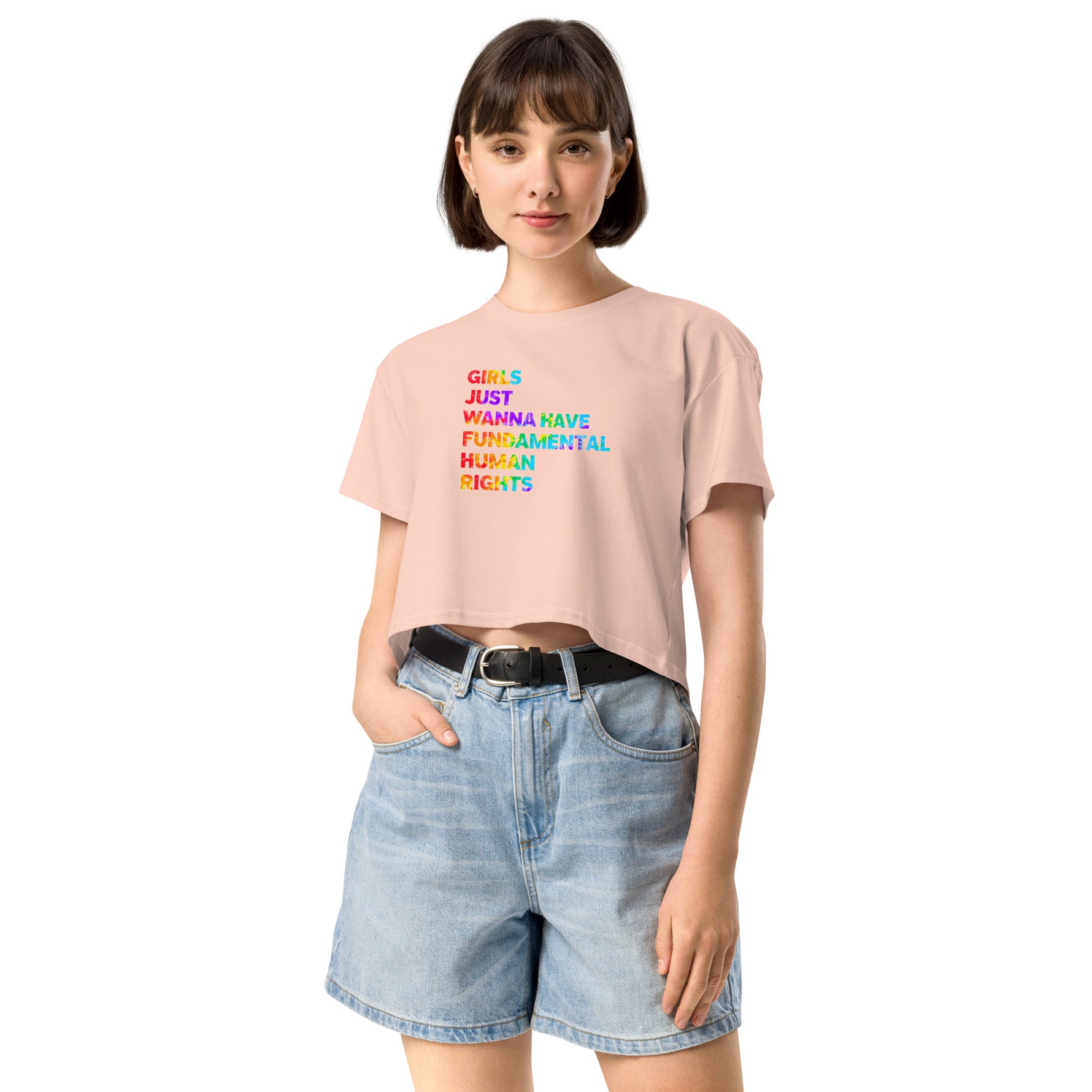 Woman wearing a pink t-shirt with colorful text and denim shorts on a white background