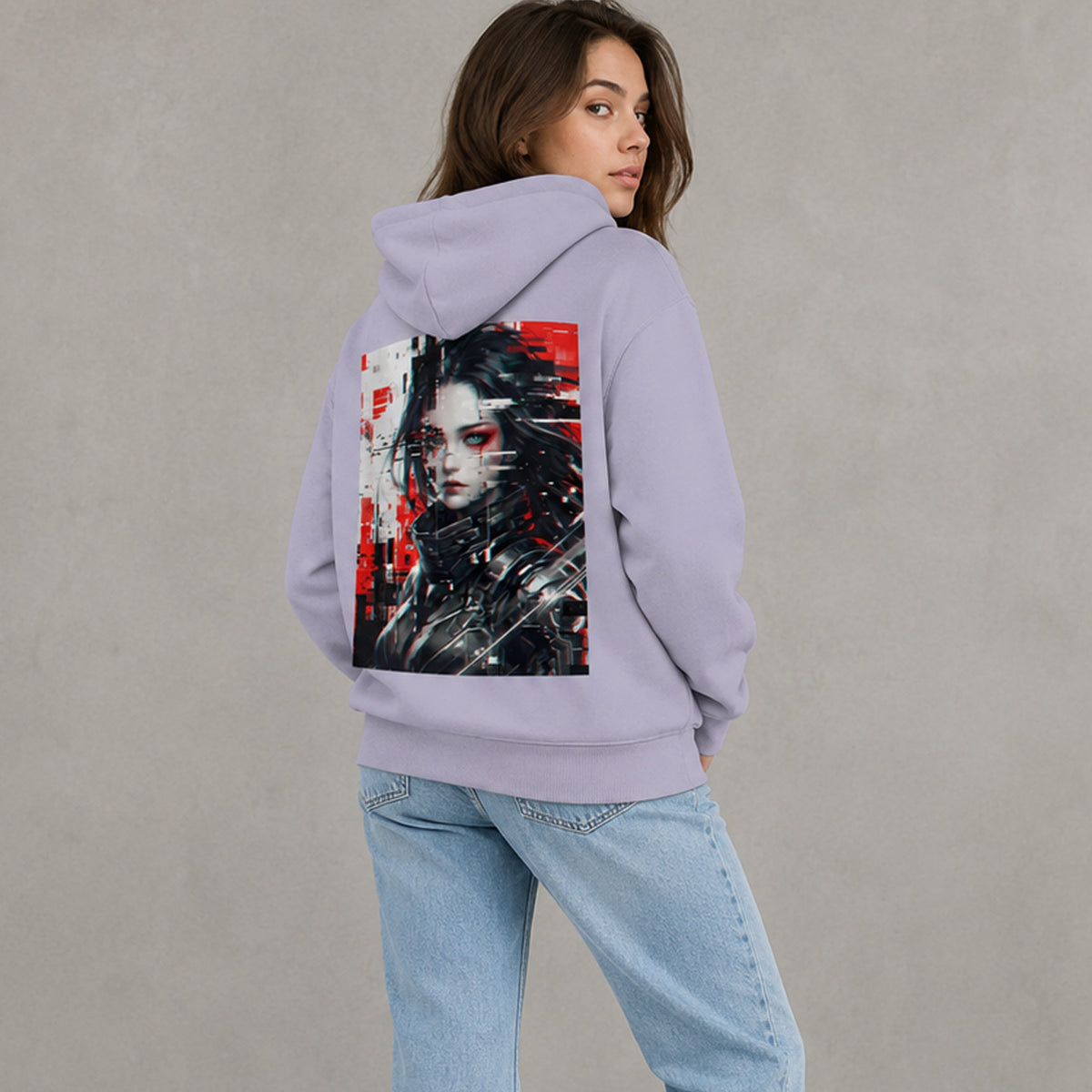 A woman wearing a light purple hoodie from the back, featuring a large graphic print of a cyberpunk-style character with red and black details. She is also wearing light blue jeans, set against a neutral gray studio background.
