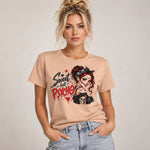 A woman wearing a light peach graphic t-shirt with a gothic 'Sweet but Psycho' design, paired with light-wash blue jeans, set against a plain light gray studio background.