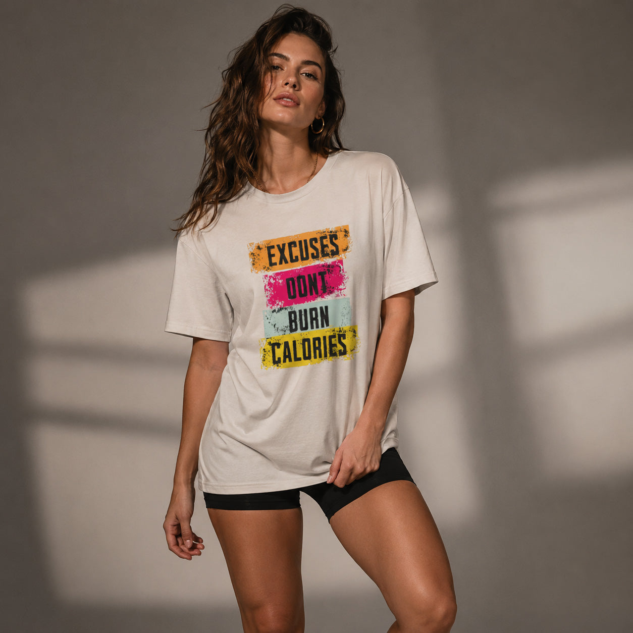 Woman wearing a t-shirt with motivational text against a neutral background