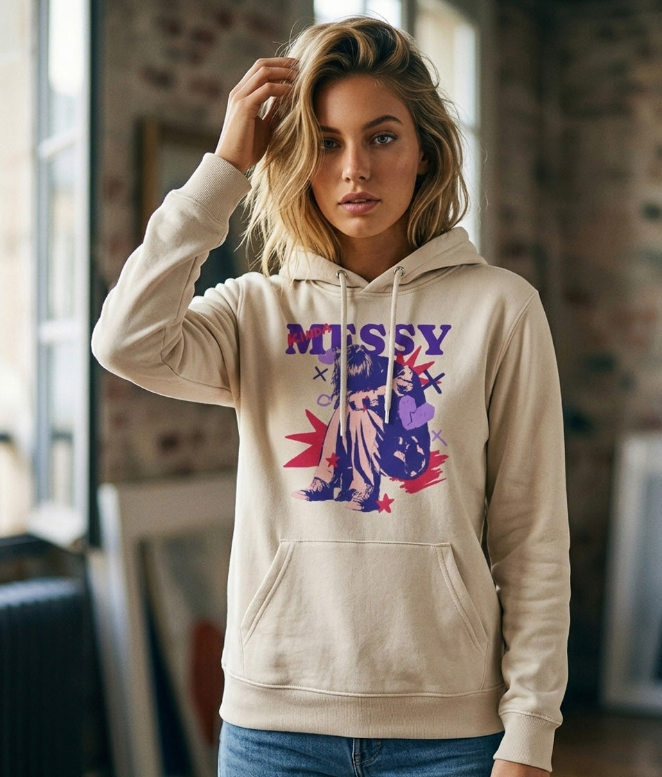 Woman wearing a beige hoodie with colorful graphic design indoors