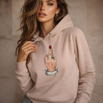 Woman wearing a beige hoodie with a graphic design on a neutral background