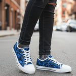 Blue and white  womens sneakers worn with black jeans on a street.