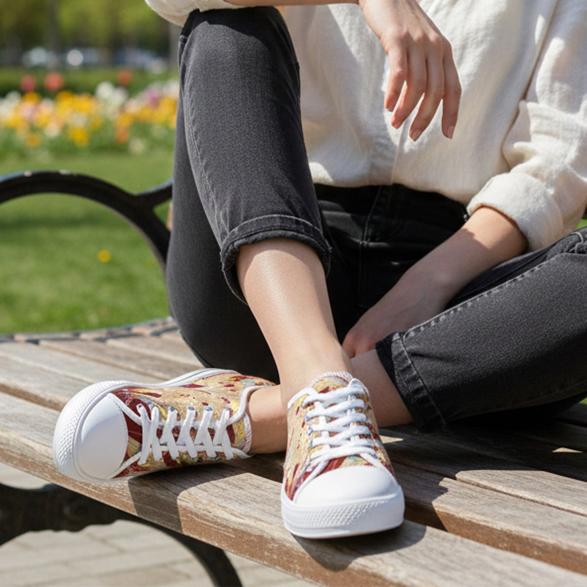 Woman wearing patterned sneakers sitting on a wooden bench with a blurred outdoor background