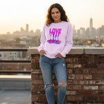 Woman wearing a pink sweatshirt with 'LOVE' printed on it, standing on a rooftop with a cityscape in the background.