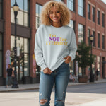 A smiling woman with curly blonde hair wears a light sweatshirt that says "I'm NOT for EVERYONE" in purple and yellow letters, standing on a city sidewalk with brick buildings and a streetlamp in the background.