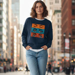 Woman wearing a navy blue sweatshirt with colorful eye design in an urban setting