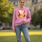 Woman wearing a pink sweatshirt with a colorful design, standing outdoors.