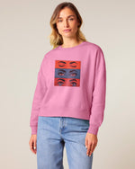 Woman wearing a Stanley/Stella pink sweatshirt with a graphic design on a plain background