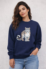 Woman wearing a navy sweatshirt with a leopard design on a light gray background