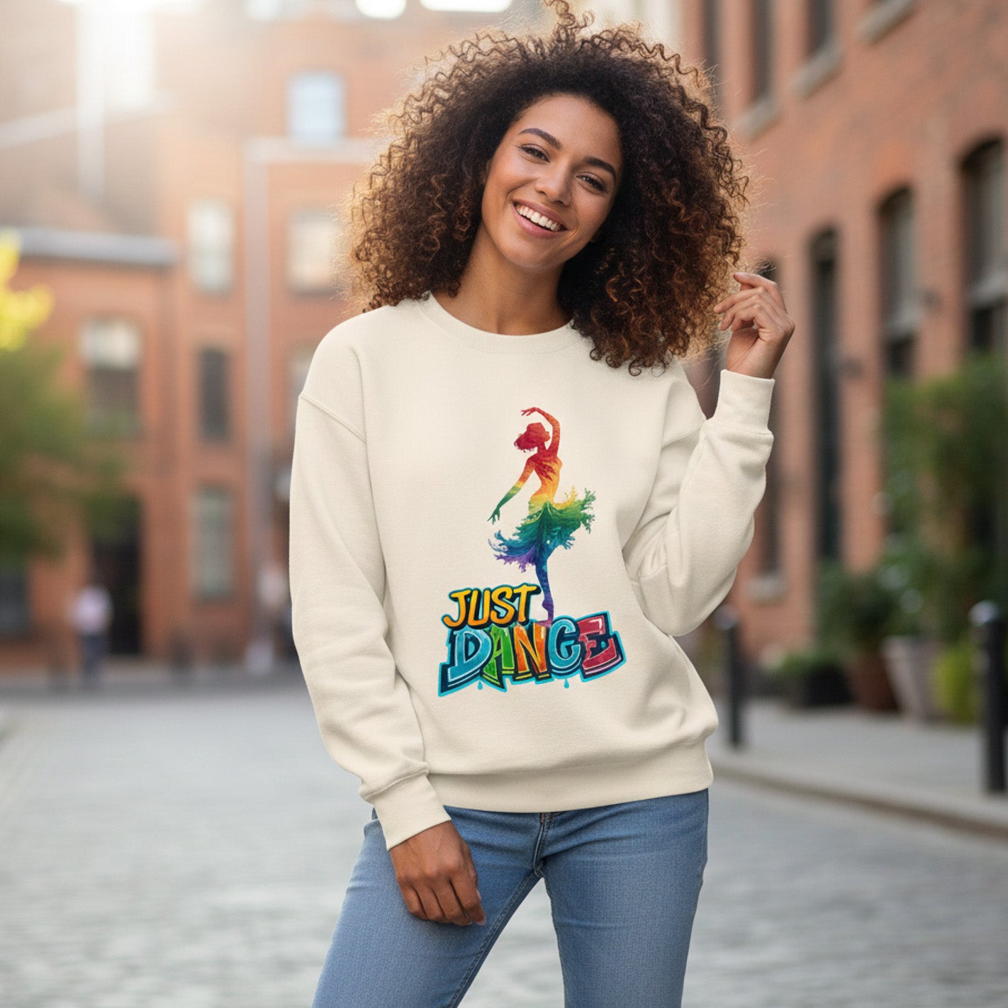 Woman wearing a cream sweatshirt with a colorful 'Just Dance' graphic on a city street.