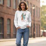 Woman wearing a white sweatshirt with a graphic design and text, standing on a street.