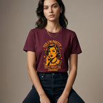 Woman wearing a maroon t-shirt with graphic design and text against a plain background