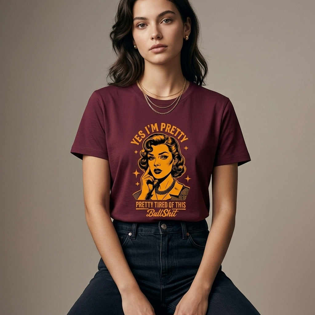 Woman wearing a maroon t-shirt with graphic design and text against a plain background