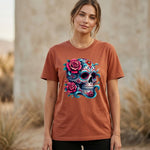 Woman wearing a brown t-shirt with a colorful skull and floral design outdoors.