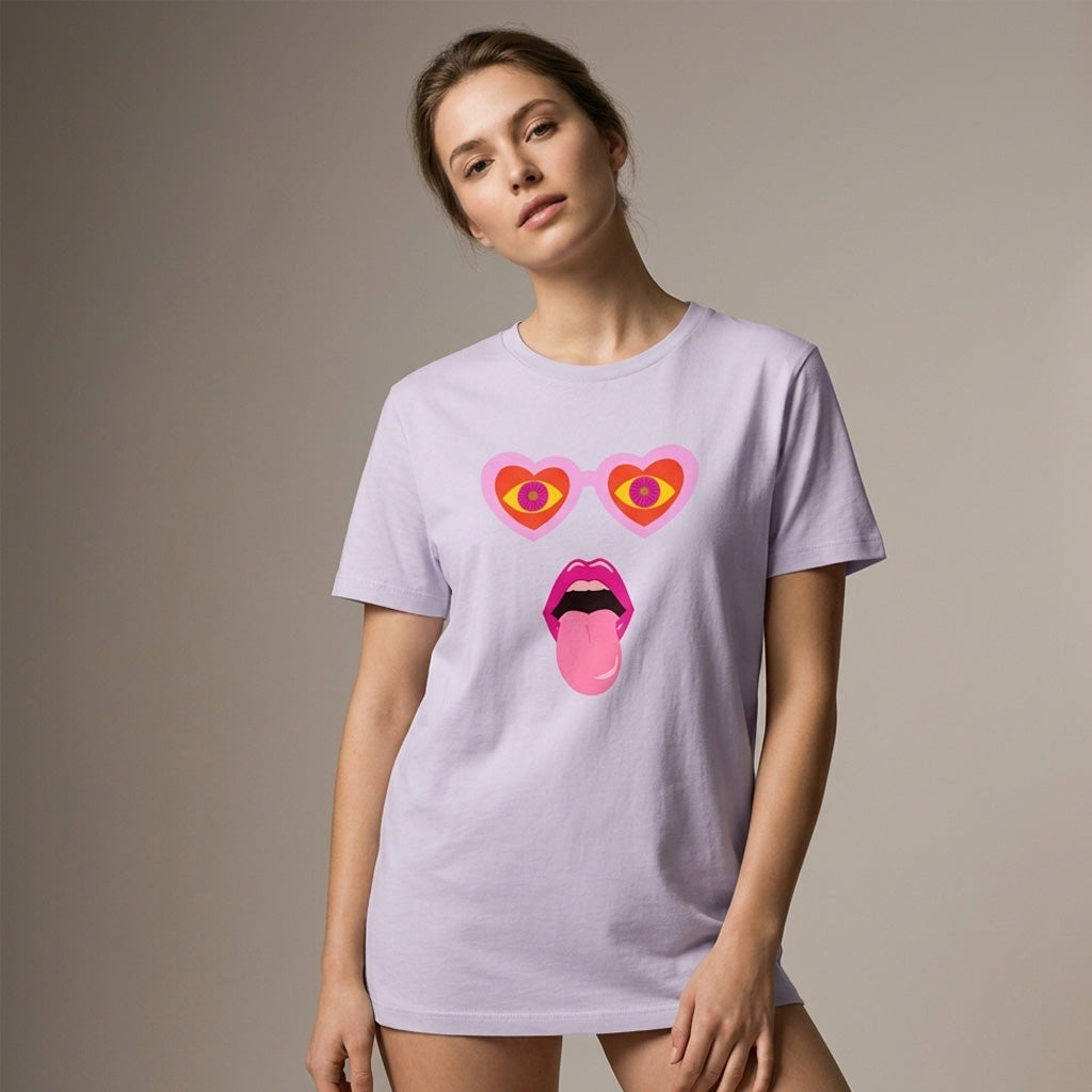 Woman wearing a light purple t-shirt with a colorful graphic design on a plain background