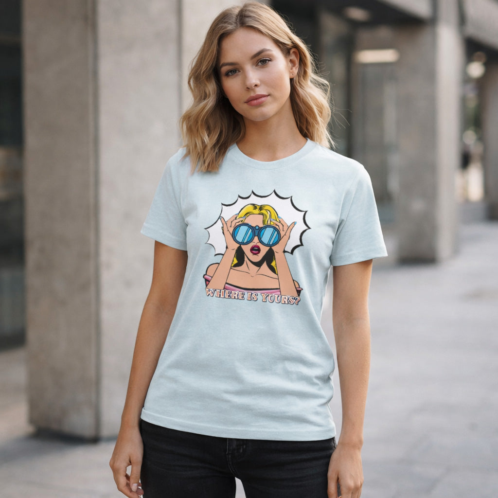 Woman wearing a light blue t-shirt with a graphic design of a woman in sunglasses and text 'WHERE IS YOURS?'.