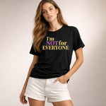 Woman wearing a black t-shirt with colorful text on a plain background