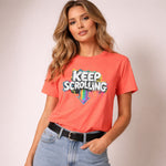 Woman wearing a coral t-shirt with 'KEEP SCROLLING' text on a plain background