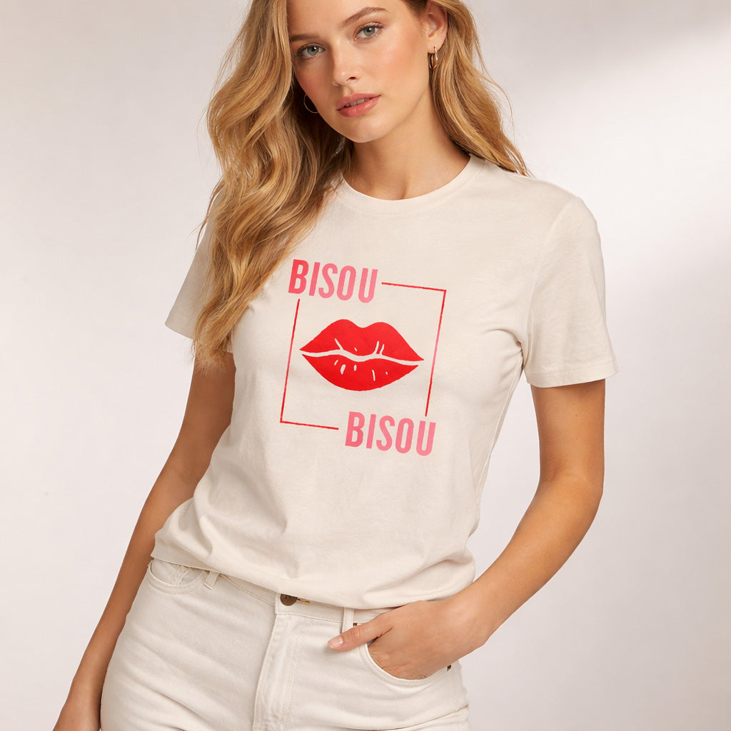 Woman wearing a white t-shirt with 'Bisou Bisou' design on a plain background