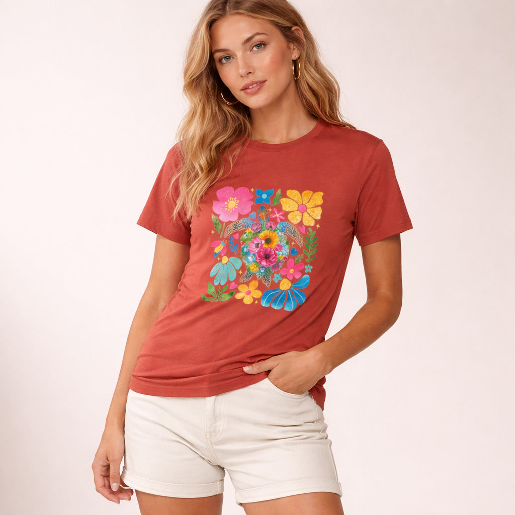 Woman wearing a red t-shirt with colorful floral design on a plain background